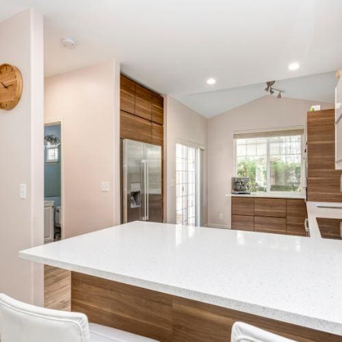 Finished kitchen: white quartz counters and walnut-front cabinets